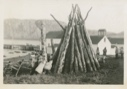 Image of Winter wood piled and children playing by one pole